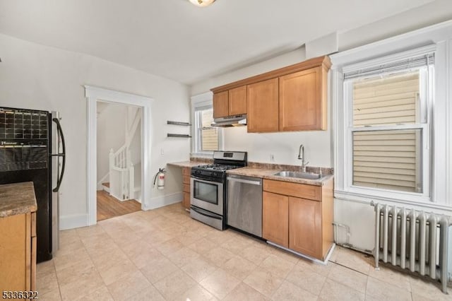 kitchen featuring radiator heating unit, stainless steel appliances, and sink