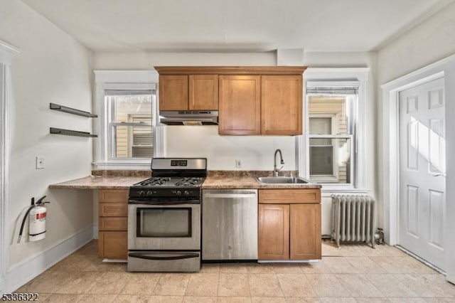 kitchen with stainless steel appliances, radiator, sink, and light tile patterned floors