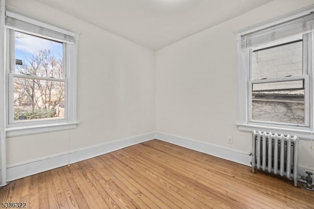 empty room with radiator heating unit and wood-type flooring