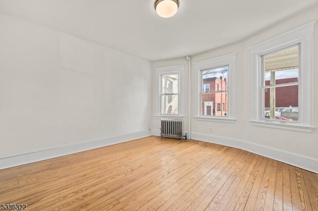 unfurnished room with radiator and light hardwood / wood-style flooring