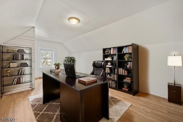 office with light hardwood / wood-style flooring and vaulted ceiling