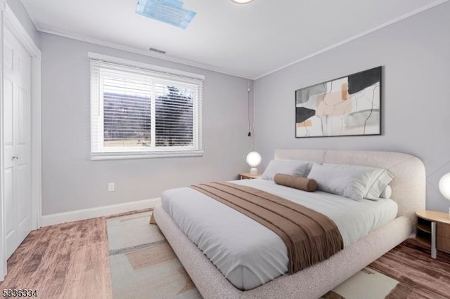 bedroom featuring hardwood / wood-style flooring and ornamental molding