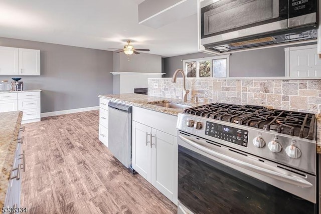 kitchen featuring tasteful backsplash, white cabinetry, appliances with stainless steel finishes, and sink