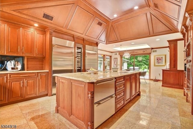 kitchen featuring a center island, coffered ceiling, light stone counters, ornamental molding, and stainless steel built in fridge