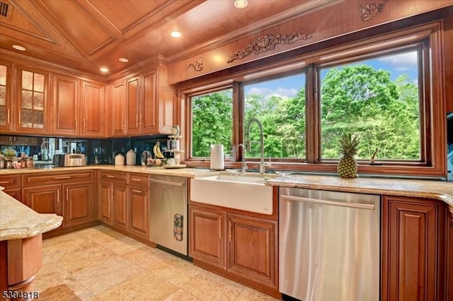 kitchen with crown molding, sink, stainless steel dishwasher, and light stone counters