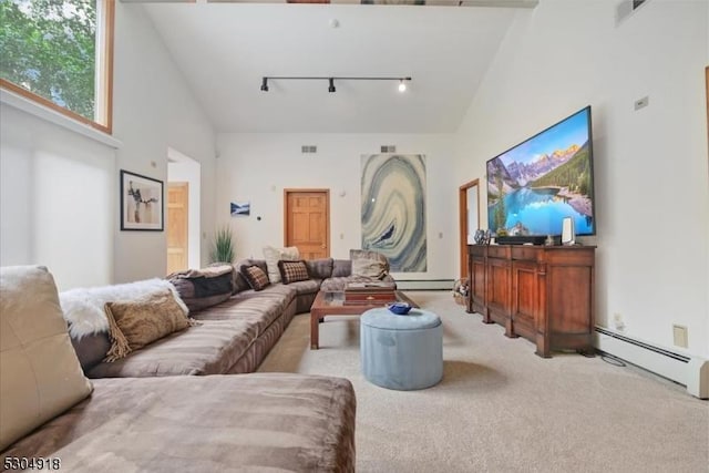 carpeted living room featuring a baseboard radiator, high vaulted ceiling, and rail lighting