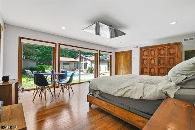 bedroom with access to exterior, multiple windows, and light wood-type flooring