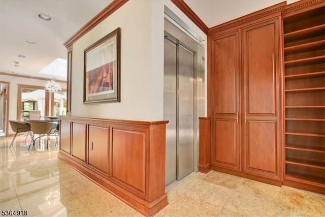 hallway featuring ornamental molding, a chandelier, and elevator