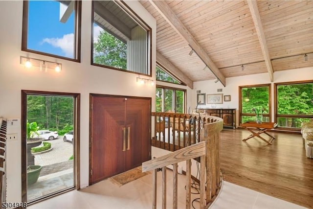 entrance foyer with wood ceiling, light tile patterned floors, high vaulted ceiling, and beamed ceiling