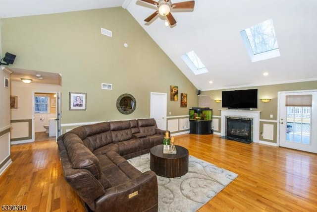 living room featuring hardwood / wood-style flooring, ceiling fan, and high vaulted ceiling