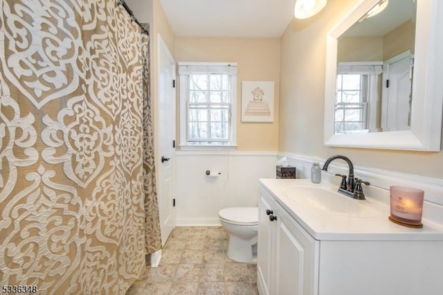 bathroom featuring vanity, plenty of natural light, and toilet