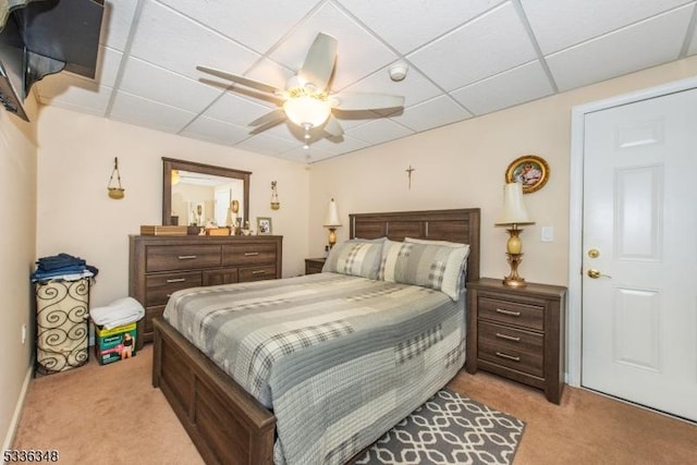 carpeted bedroom featuring a drop ceiling and ceiling fan