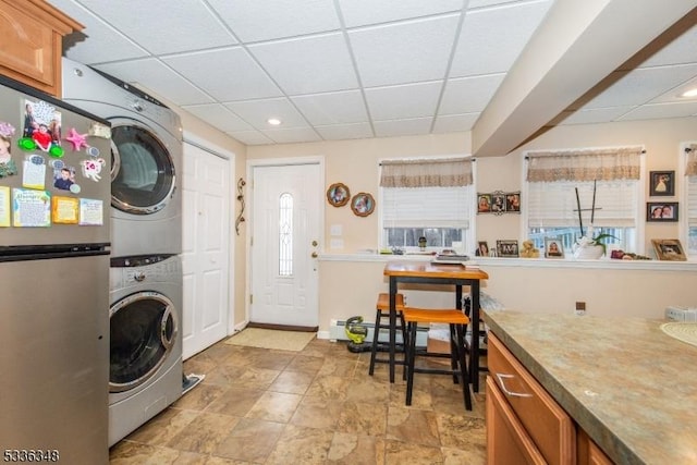 washroom featuring a baseboard radiator and stacked washer / drying machine