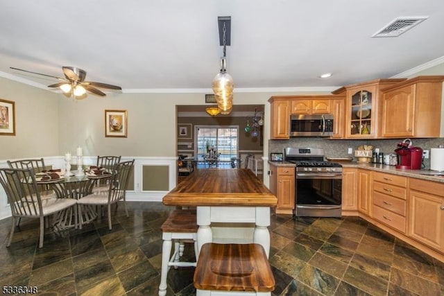 kitchen with pendant lighting, backsplash, crown molding, and appliances with stainless steel finishes