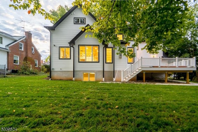 rear view of property with a yard and a deck