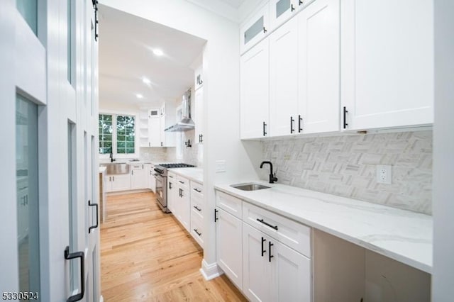 kitchen with white cabinets, sink, and stainless steel gas range oven