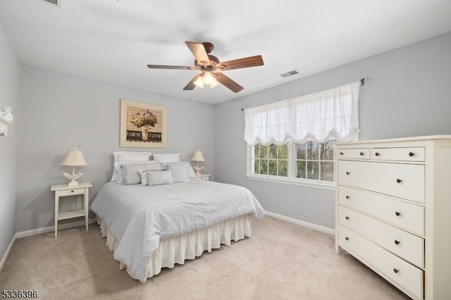 bedroom with baseboards, ceiling fan, visible vents, and light colored carpet