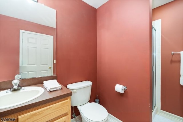 bathroom with vanity, a shower stall, and toilet