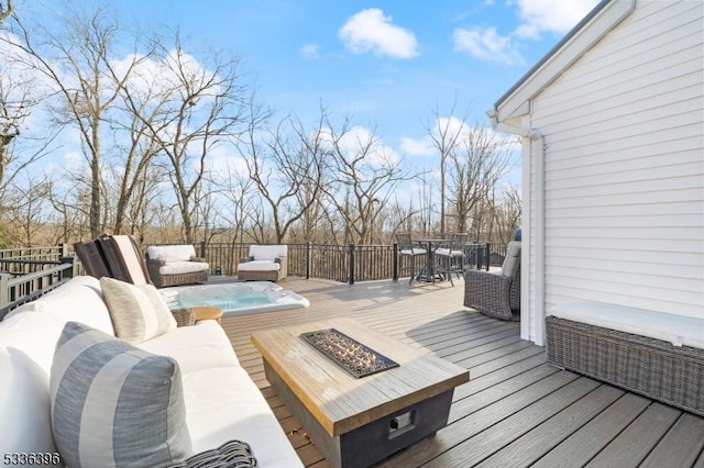 wooden terrace featuring outdoor dining area and an outdoor living space with a fire pit