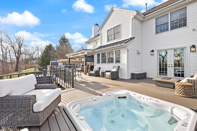 wooden terrace with outdoor dining space, french doors, hot tub deck surround, and an outdoor living space