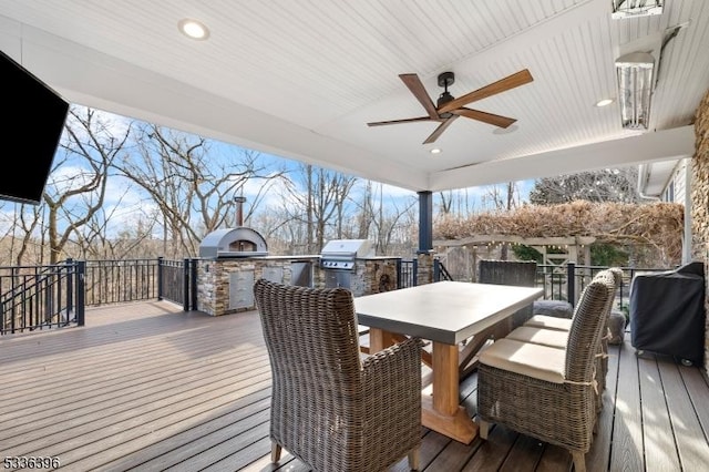 wooden deck featuring ceiling fan, outdoor dining space, an outdoor kitchen, and a grill