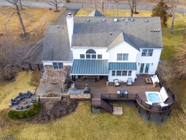 back of property with french doors, an outdoor living space with a fire pit, outdoor dining area, a fenced backyard, and a wooden deck