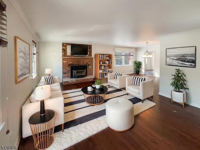 living room featuring dark hardwood / wood-style flooring, a brick fireplace, and crown molding