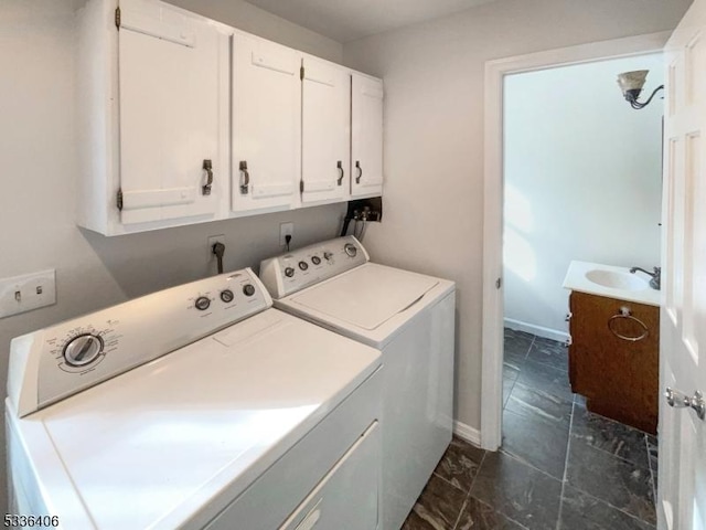 laundry room with cabinets, washing machine and dryer, and sink