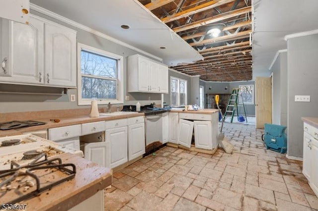 kitchen featuring sink, white cabinets, stainless steel dishwasher, kitchen peninsula, and crown molding