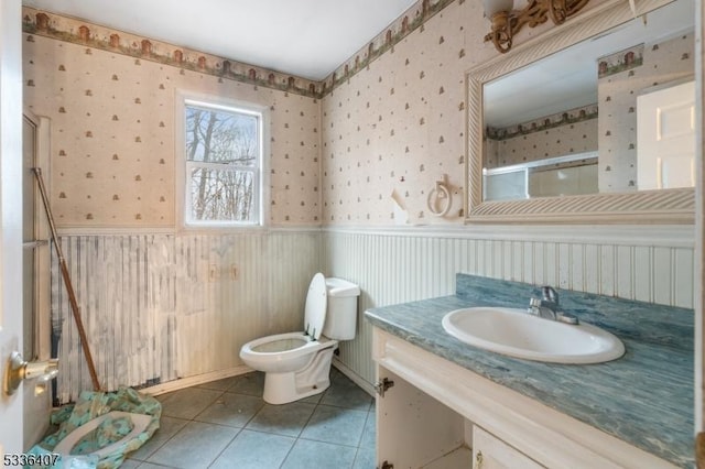 bathroom featuring tile patterned floors, toilet, an enclosed shower, and vanity