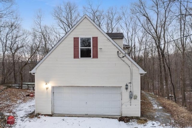 view of snow covered exterior with a garage