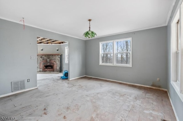 unfurnished room with crown molding and a stone fireplace