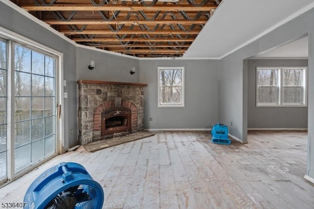 unfurnished living room featuring ornamental molding, plenty of natural light, and a fireplace