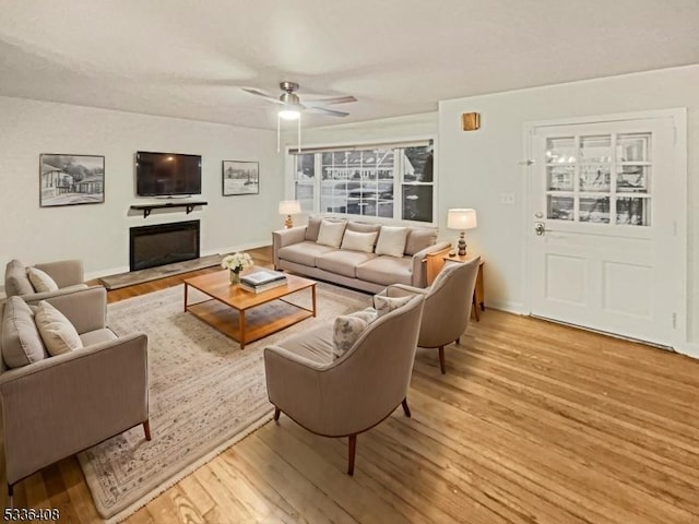 living room with ceiling fan and wood-type flooring