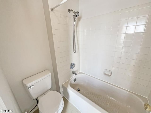 bathroom featuring tiled shower / bath combo and toilet