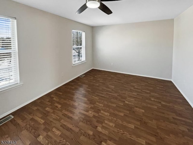 empty room featuring dark wood-type flooring and ceiling fan