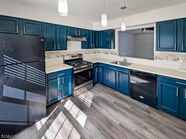 kitchen featuring pendant lighting, sink, black appliances, light hardwood / wood-style floors, and blue cabinets