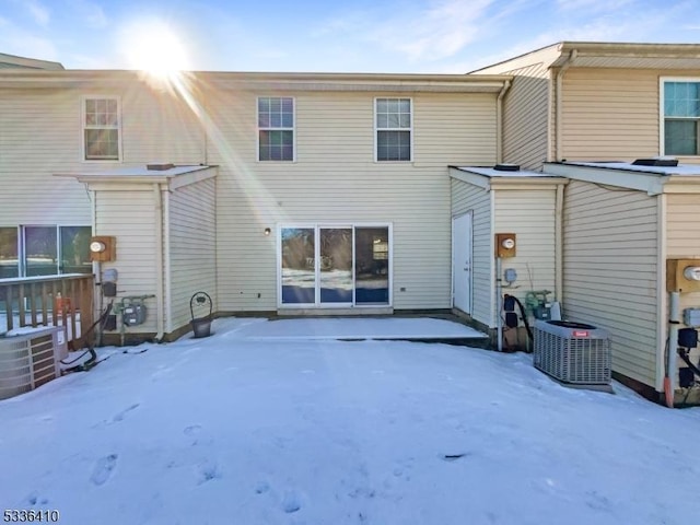 snow covered house featuring central air condition unit