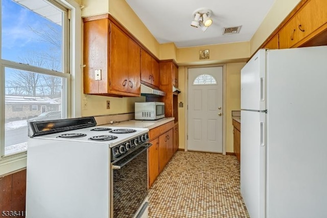 kitchen featuring a wealth of natural light and white appliances