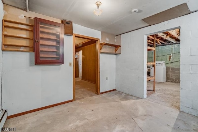 empty room featuring a baseboard heating unit and washer / dryer