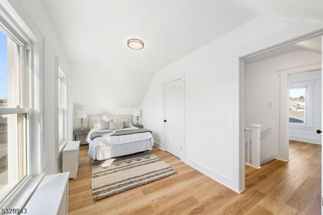 bedroom featuring lofted ceiling and light hardwood / wood-style floors