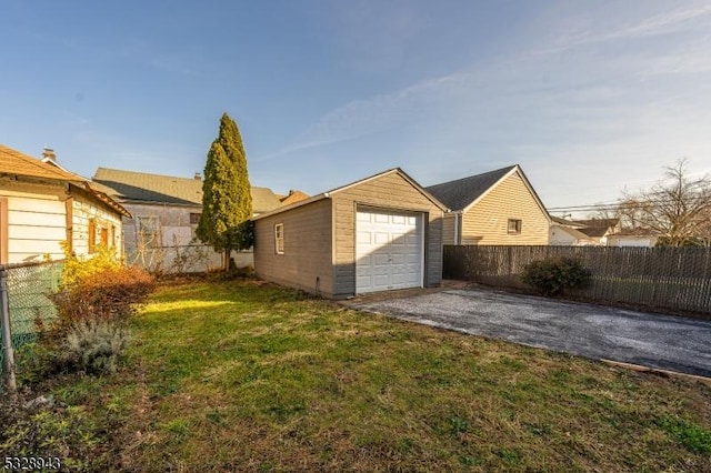 exterior space with an outbuilding, a garage, and a lawn