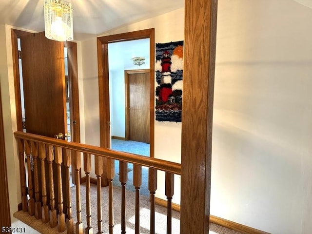 corridor featuring carpet and a chandelier