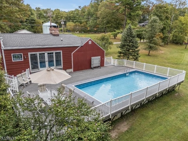 view of swimming pool featuring a yard and a deck