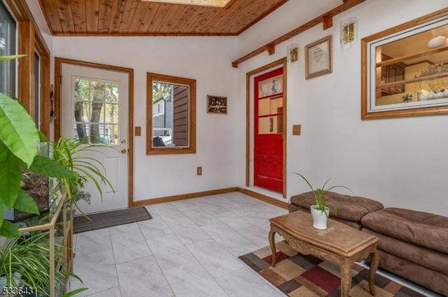 entryway with lofted ceiling with skylight and wooden ceiling