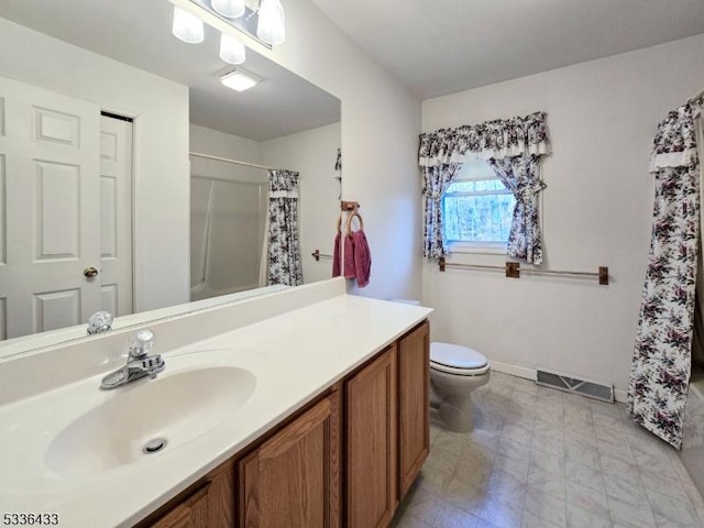 full bathroom with vanity, shower / bath combo, and toilet