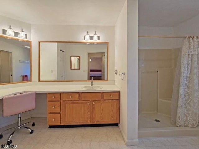 bathroom featuring walk in shower and vanity