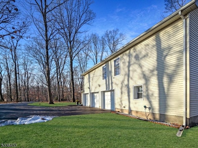 view of home's exterior featuring a garage and a lawn