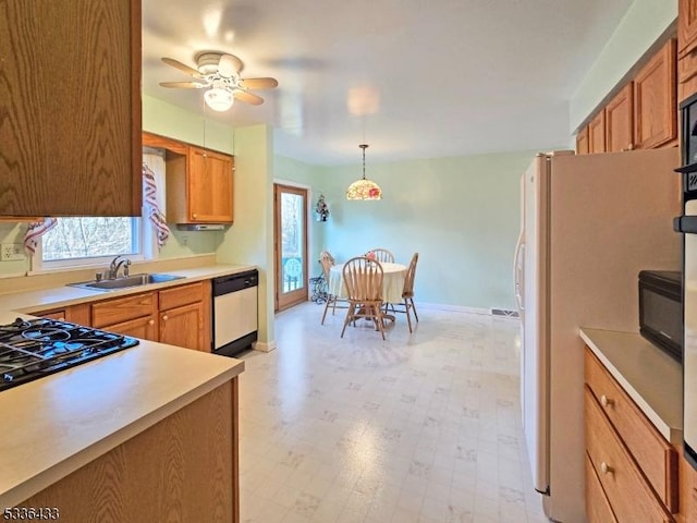 kitchen featuring sink, decorative light fixtures, stainless steel dishwasher, white fridge, and ceiling fan