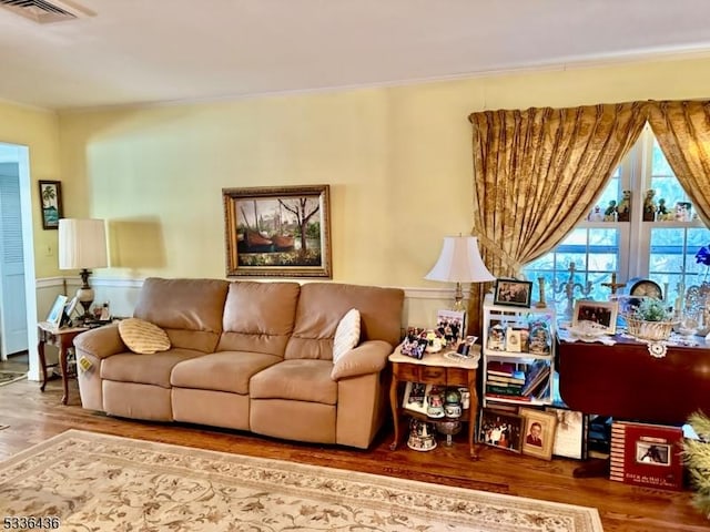 living room with wood-type flooring and ornamental molding